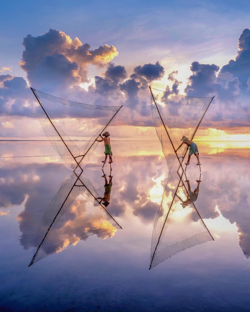 brings us the ethereal reflected scene of locals hunting seafood on Quang Lang B...